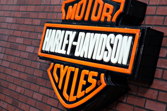Harley Davidson logo is displayed on a brick  wall